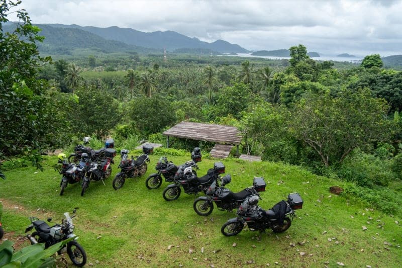 Motorcycles parked in lush green Thai scenery