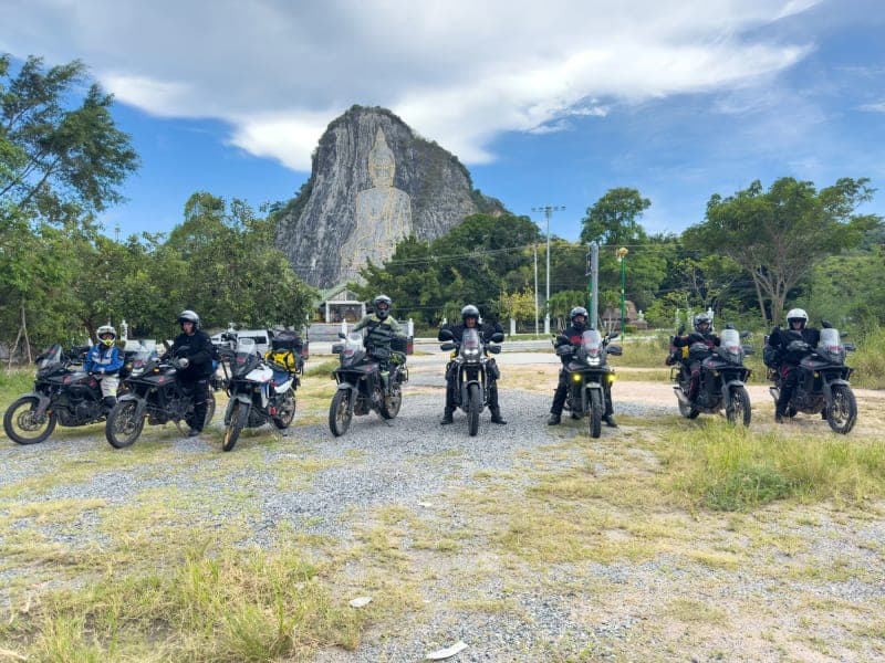Motorcycle parked beside a serene silver lake in Thailand